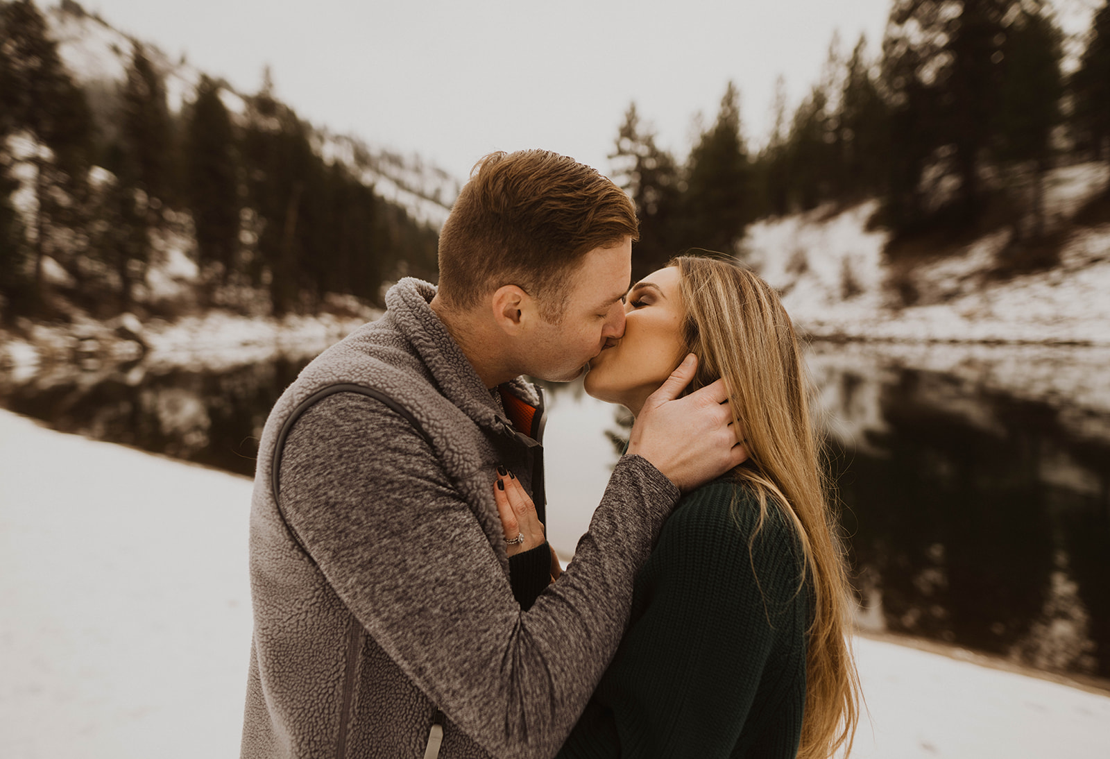 couple kisses in front of the payette river during their couple session