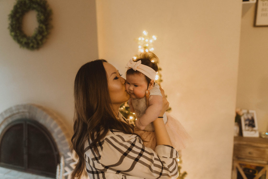 mom kisses her baby on the cheek during their seattle family lifestyle session at christmas