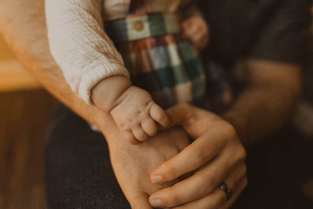 close up photo of baby with her father's hands during the seattle family lifestyle session