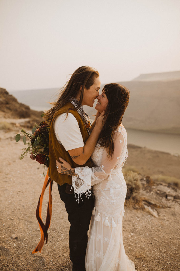 brides smile and kiss during their snake river canyon elopement in idaho