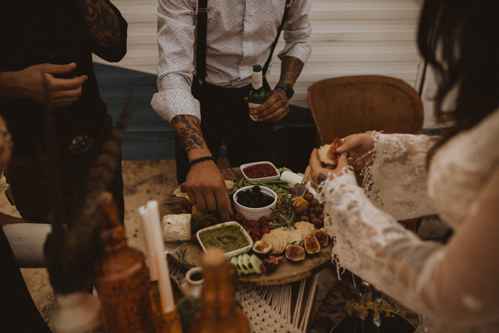 wedding guests gather around a charcuterie board during the snake river canyon elopement reception