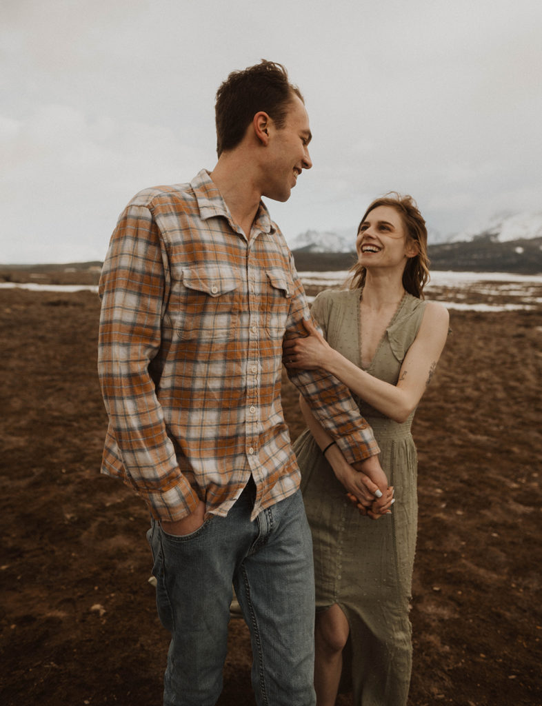 couple walks together during their engagement session in the sawtooth mountains