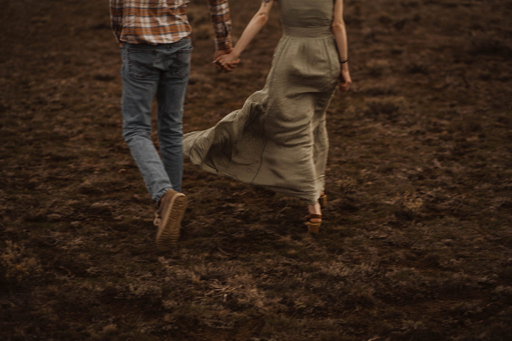 couple holds hands during their Sawtooth mountains engagement session